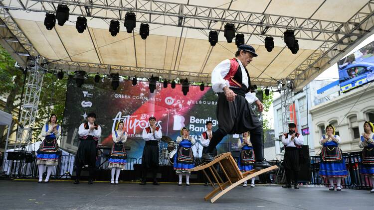 Performers in traditional dress dancing on stage. 