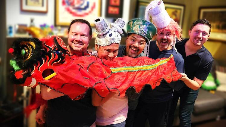 Five people holding a dragon puppet