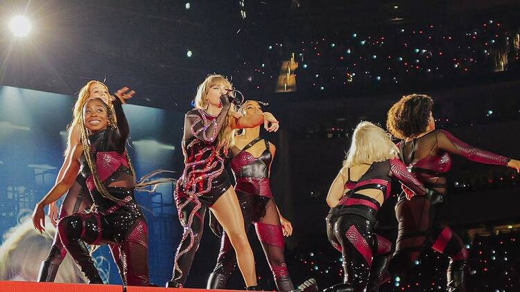 Taylor Swift performing on stage with backup dancers