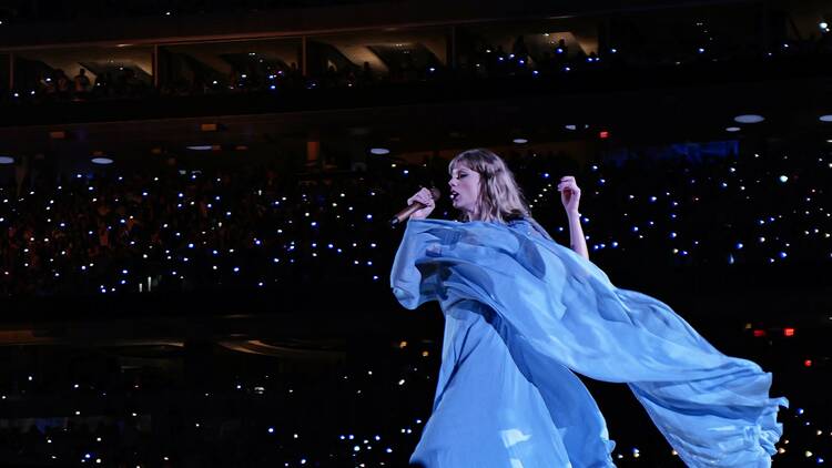 Taylor Swift on stage with a flowing dress