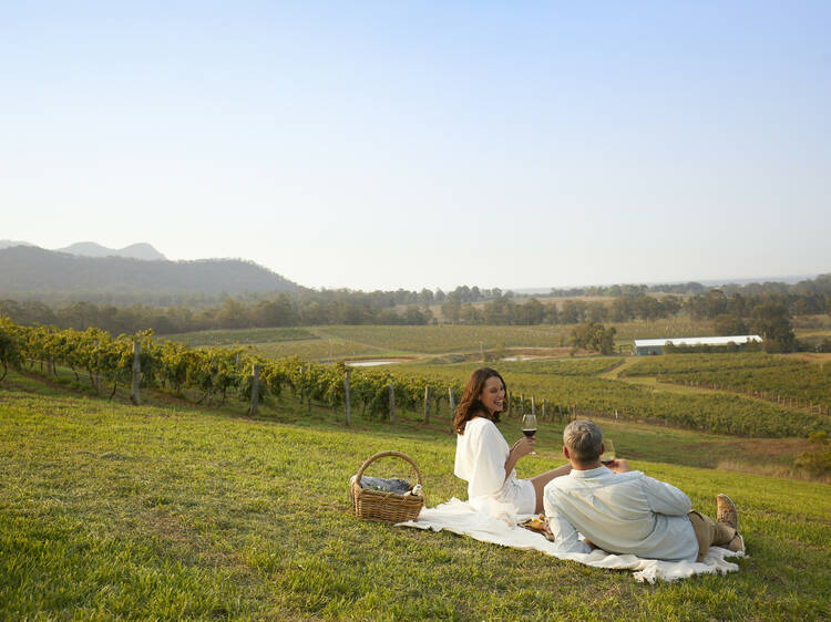 Couple enjoying a picnic at Audrey Wilkinson, Pokolbin in the Hunter Valley region.