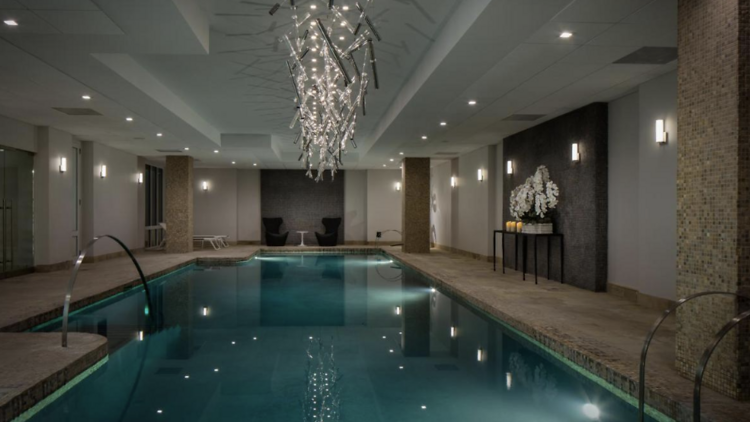 Indoor pool with hanging chandelier at AKA Sutton Place hotel
