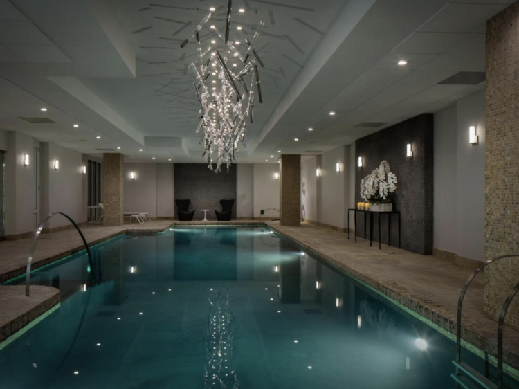 Indoor pool with hanging chandelier at AKA Sutton Place hotel