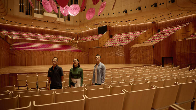 Three people inside a theatre of the Opera House 