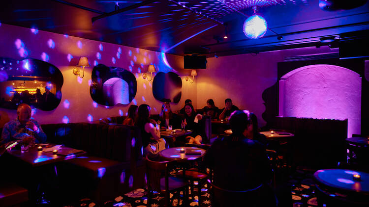 A purple-hued bar with disco light.