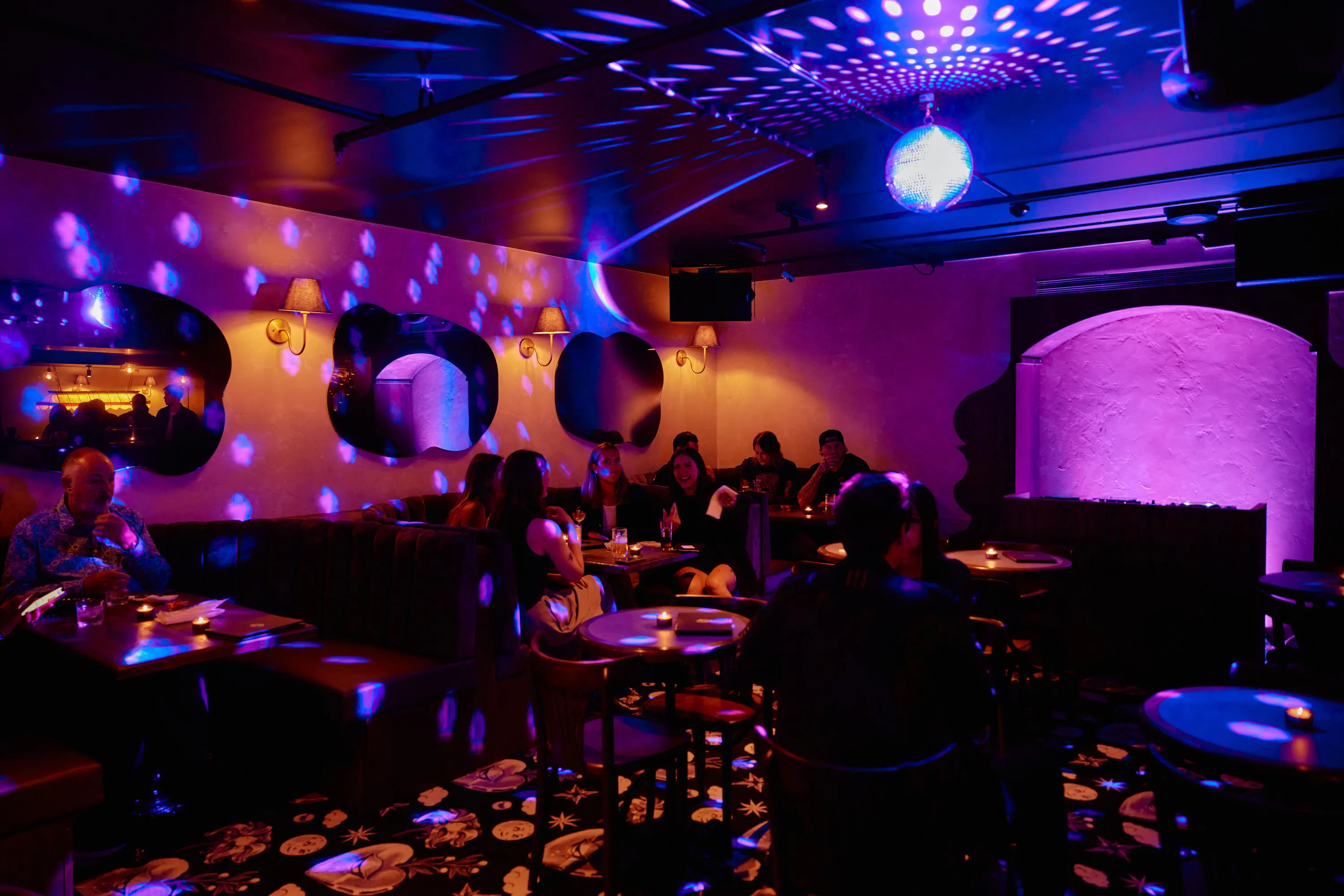 A purple-hued bar with disco light.