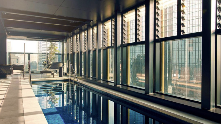 Indoor pool  with panelled floor to ceiling windows at the Quincy Hotel Melbourne. 