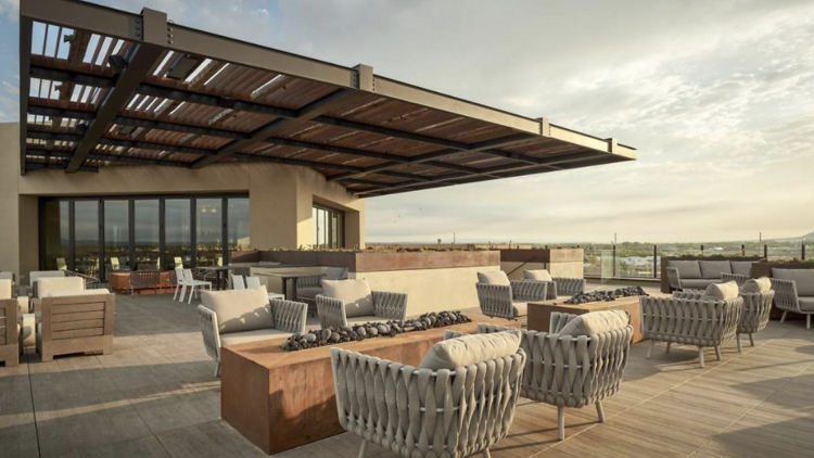 Hotel Chaco's outdoor terrace on a sunny day with serval chairs and loungers.