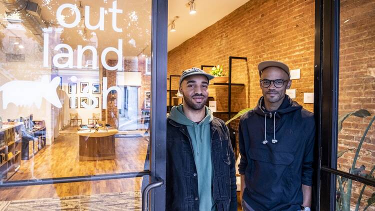 two people stand outside a store front