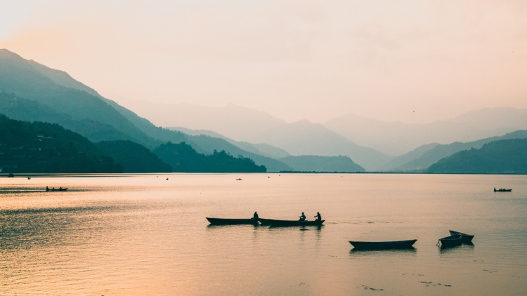 Phewa Lake at dusk with boats on the water
