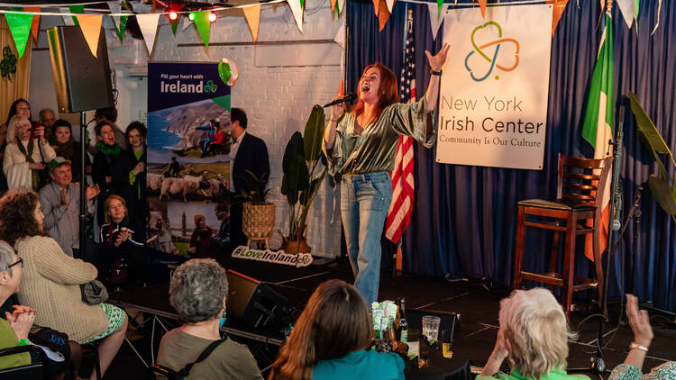 A woman sings at the Irish Center.