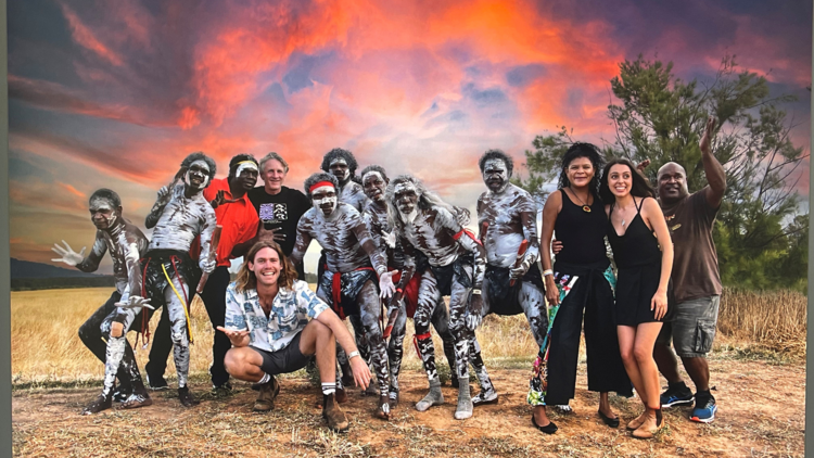 Yothu Yindi and friends stand in front of a sunset