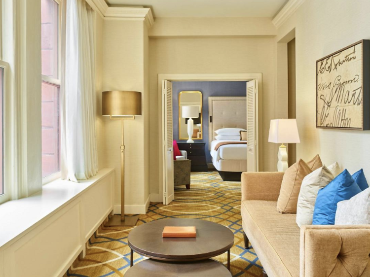 Sitting room with a sofa facing large windows in suite at the The Brown Palace Hotel and Spa