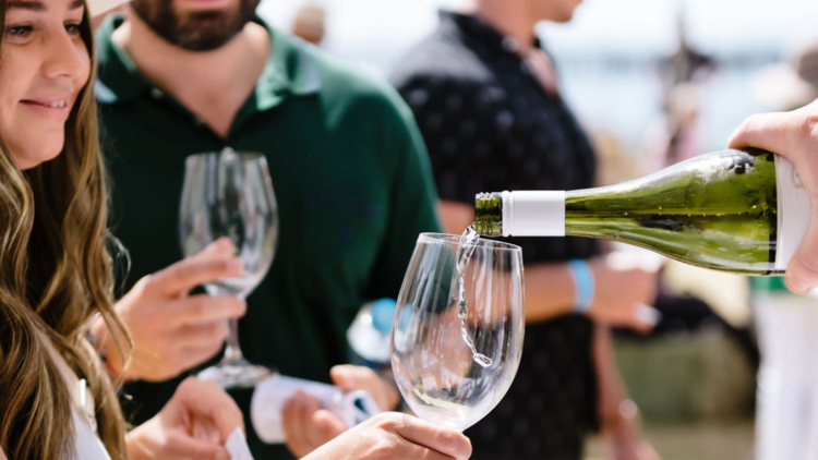 Woman receiving wine in a glass for a tasting session.