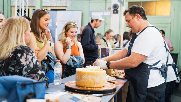 Women observing a cheese-maker's demonstration.