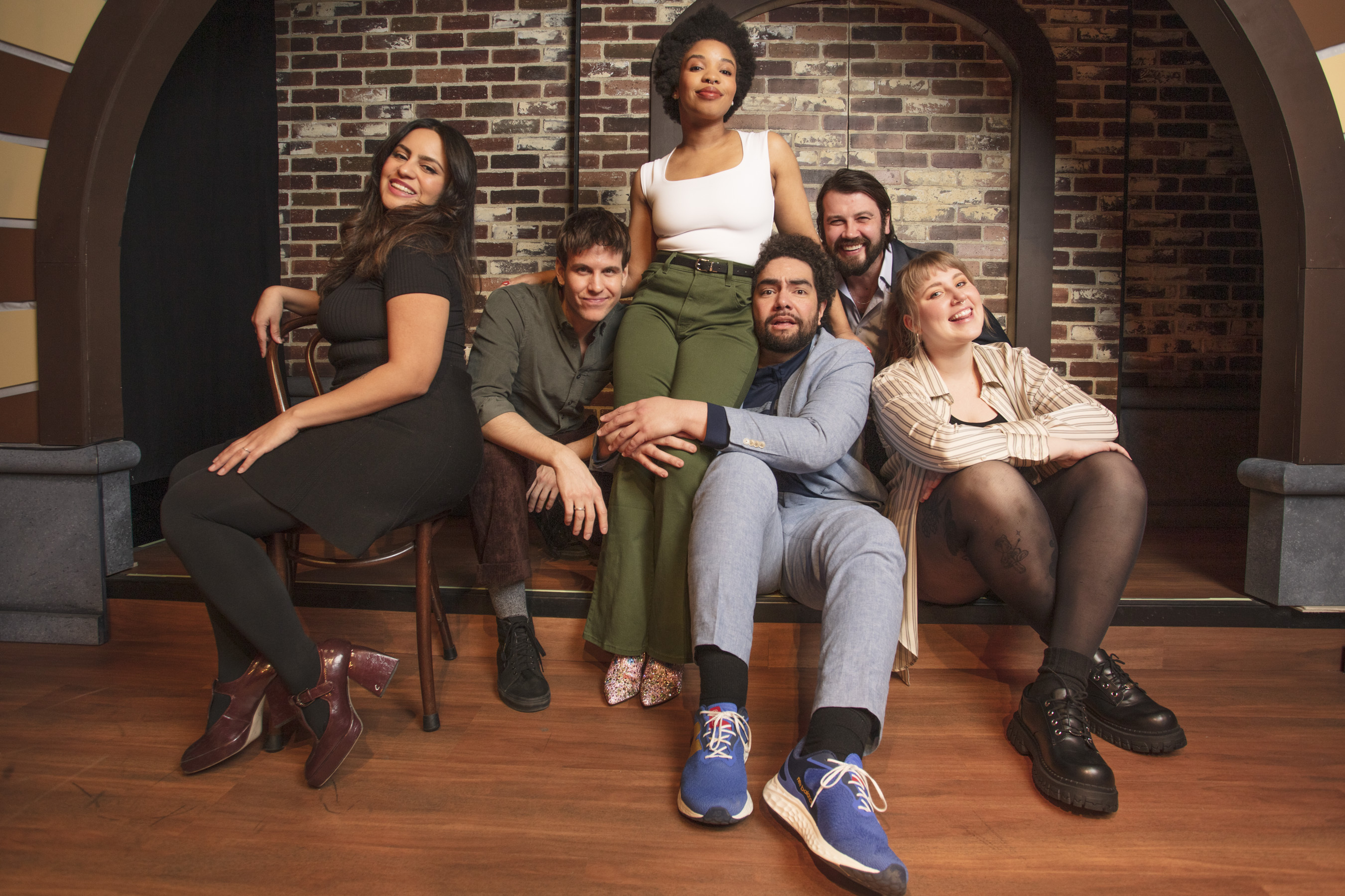 The Second City cast poses on stage.