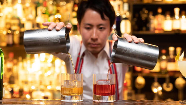 Bartender doing a double pour while making drinks.