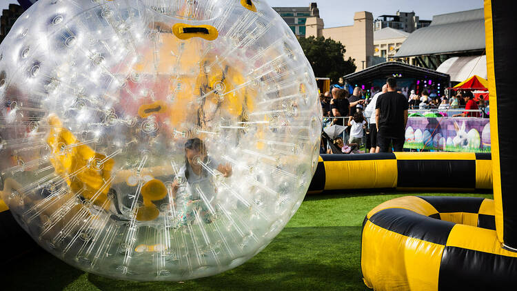 A giant ball with a kid inside pushing it around 