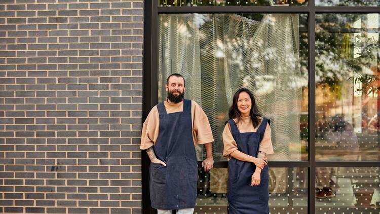 Two people standing in front of a restaurant