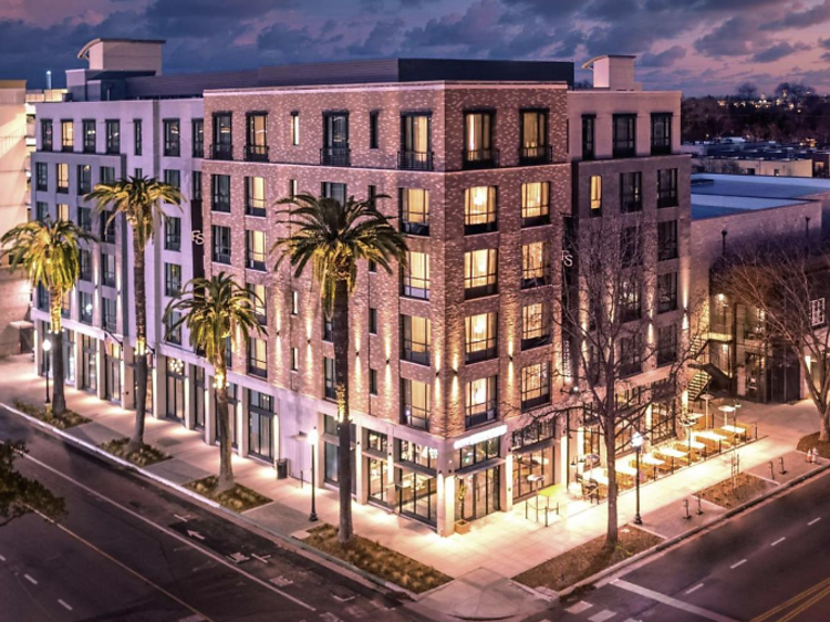 Exterior tower of Fort Sutter Hotel Sacramento lit up at night time.