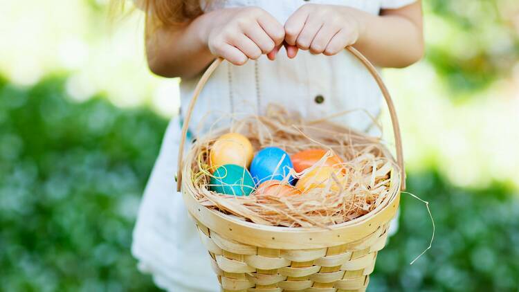 A child holding a basket of easter eggs