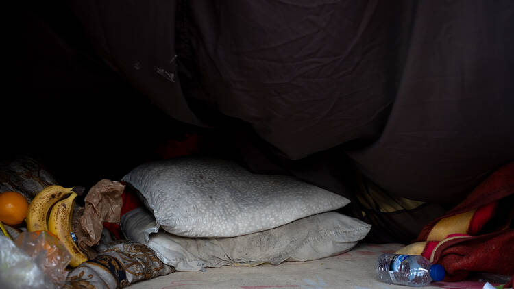 o interior de uma tenda com almofadas, fruta e água