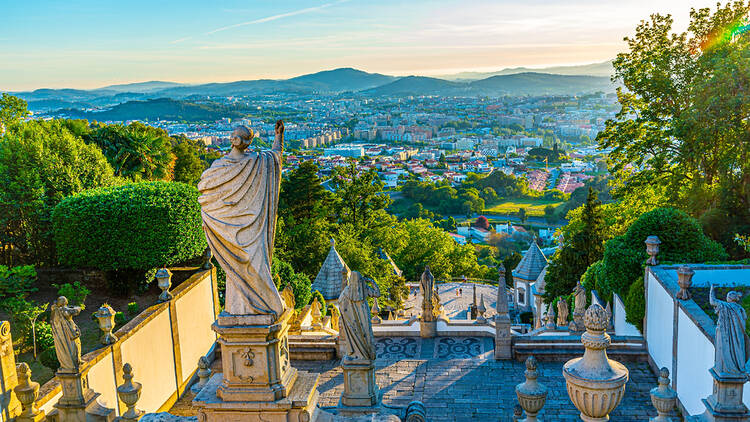 The city of Braga in Portugal, showing a statue in the forefont overlooking the city in the background