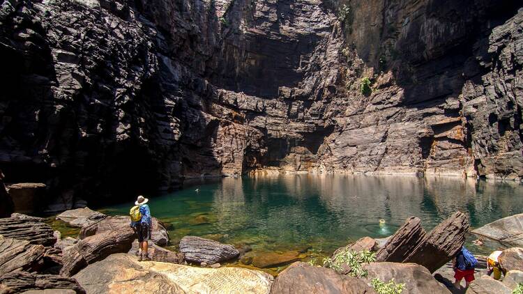 People exploring a rocky swimming hole