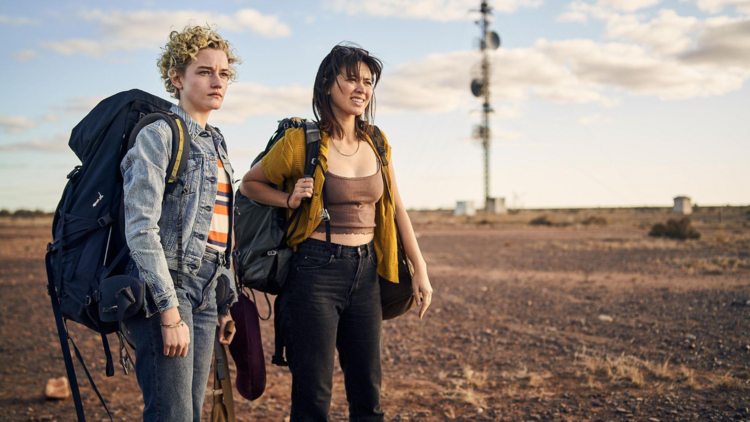 A still from the film Royal Hotel showing two women standing in the Australian Outback