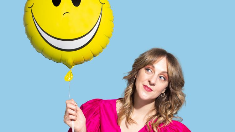Gillian Cosgriff holds a yellow smiley face balloon
