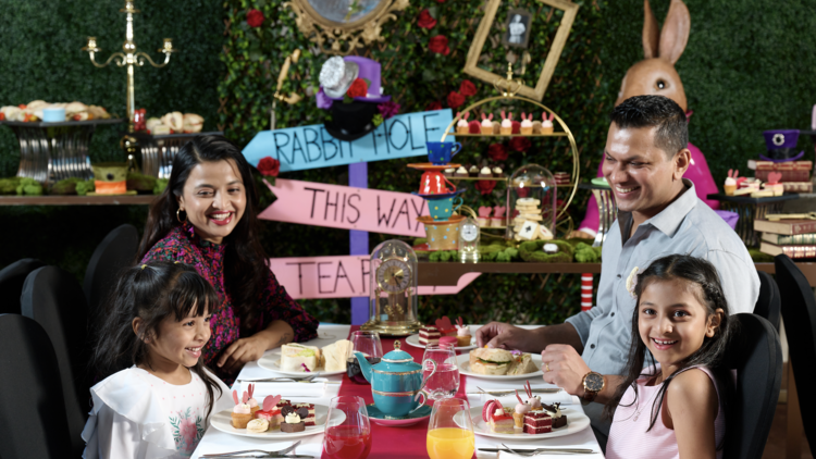 a family at an alice and wonderland themed table