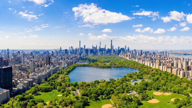 Aerial view of the Central park in New York with golf fields and tall skyscrapers surrounding the park.