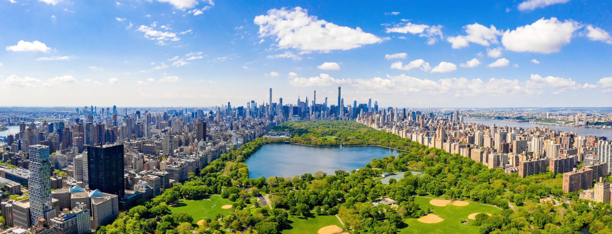 Aerial view of the Central park in New York with golf fields and tall skyscrapers surrounding the park.