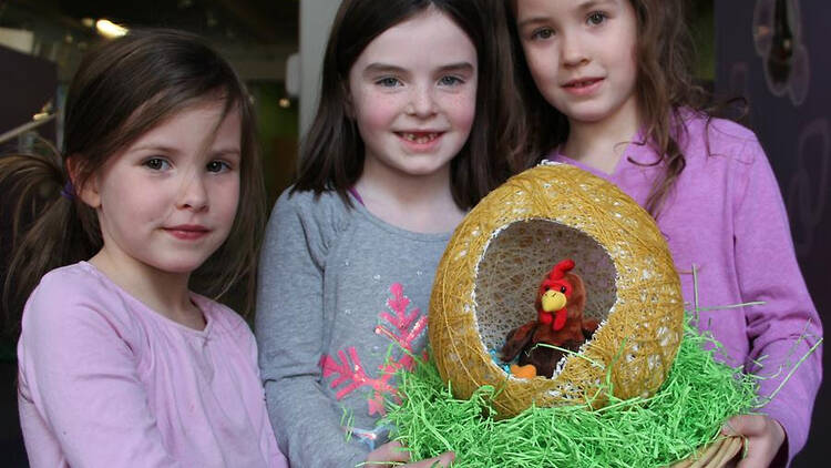 three kids holding an Easter themed decoration