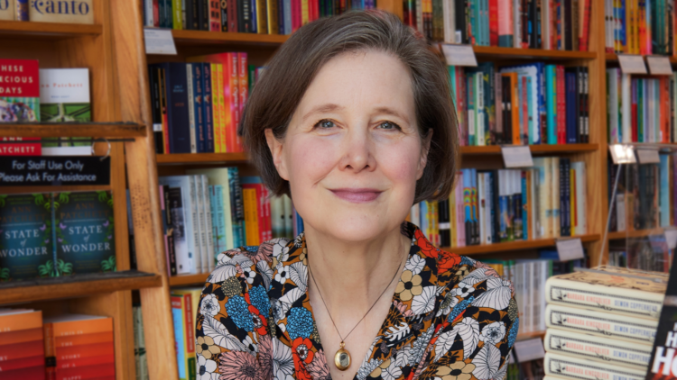 Ann smiling in front of book shelves