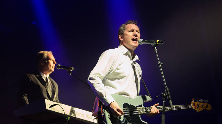 The two members of OMD performing on a dark stage 