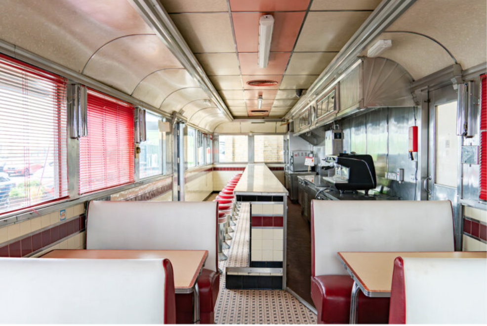 Inside Fat Boy's Diner with red blinds, red stools red booths 