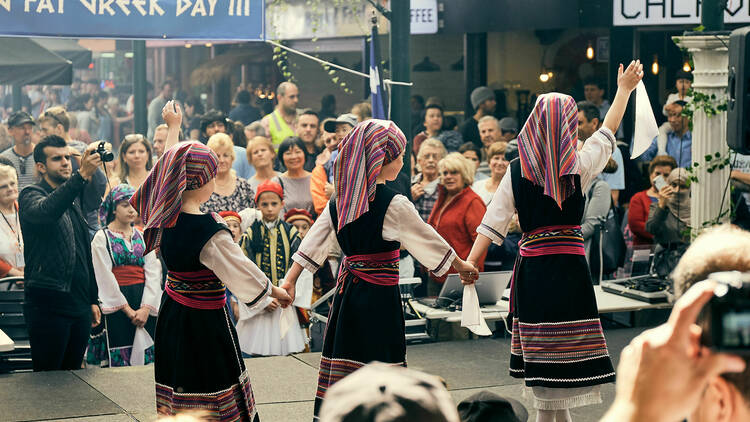 Children in traditional Greek clothing performing a dance. 