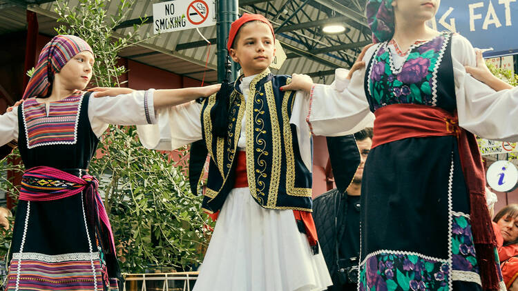 Children in traditional Greek clothing performing. 