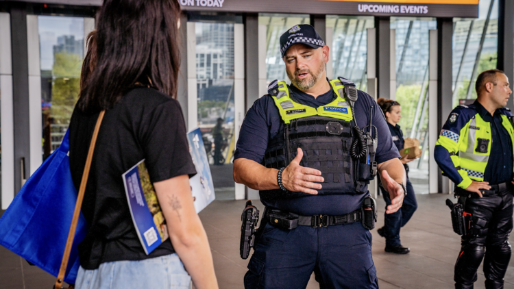 A male police officer talking to a young woman