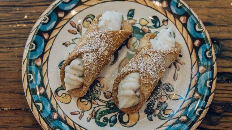 Two cannoli on a blue and white plate