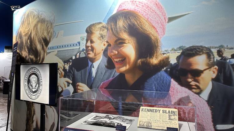 A photograph of Jackie and John F. Kennedy in front of an airplane. 