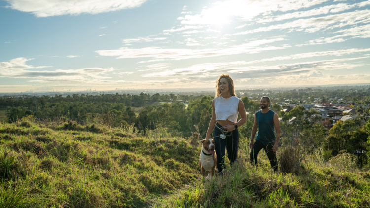 A woman and man walking up a hill in sunny daylight