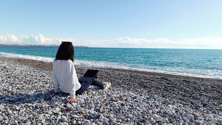 Woman on beach with laptop