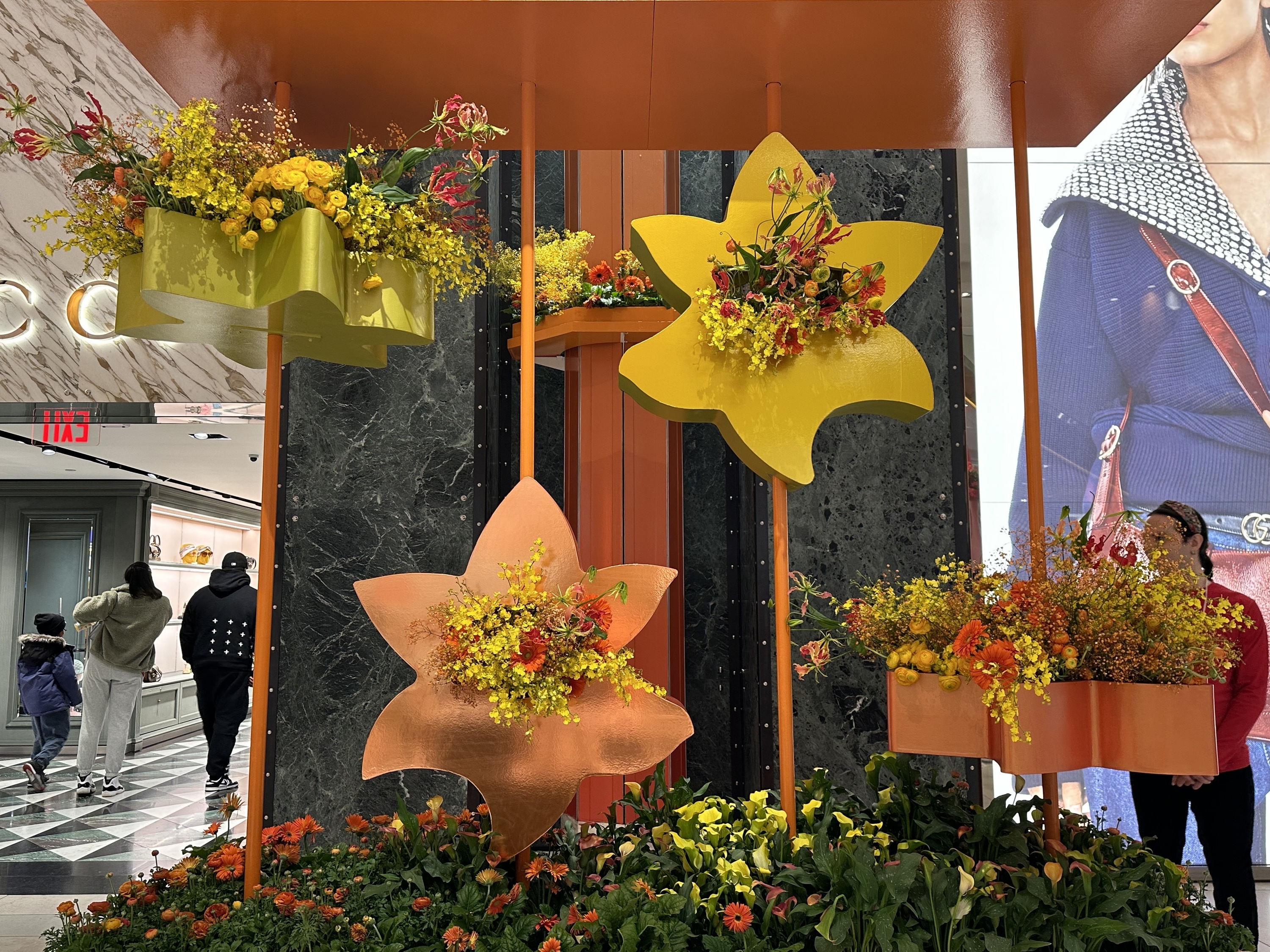 Yellow and orange flowers burst from a floral display.