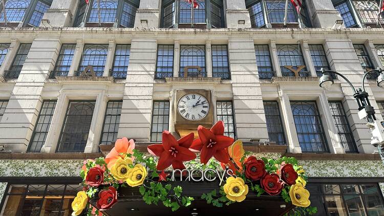 The exterior of Macy's with a floral display.