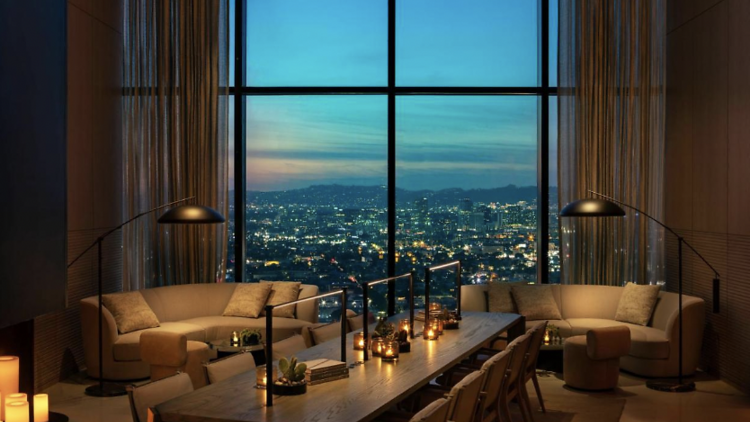 Candlelit lounge with two sofas and a window with panoramic views of downtown LA.