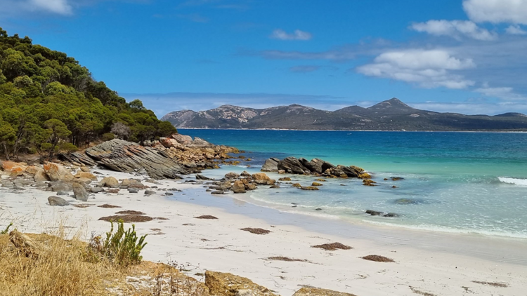 Bay with clear waters and mountains in the background