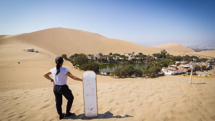 Sandboarding down golden dunes in Huacachina