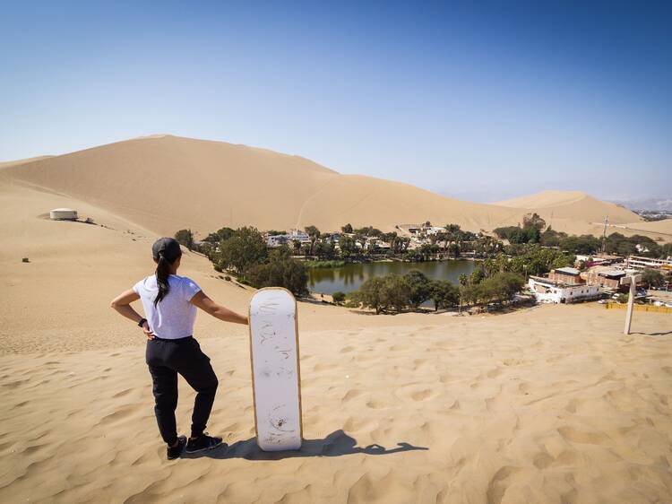 Sandboarding down golden dunes in Huacachina